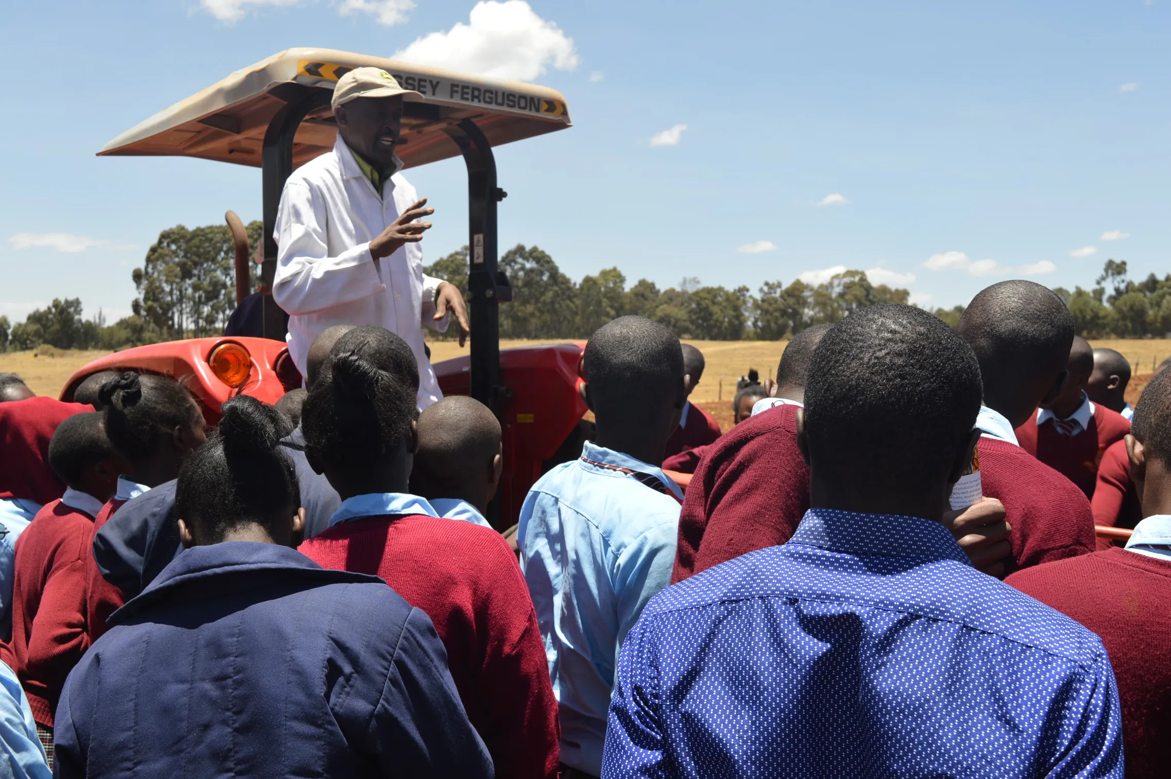 Kariuki Njunge from AMS showcasing a harvester to a visiting school group.