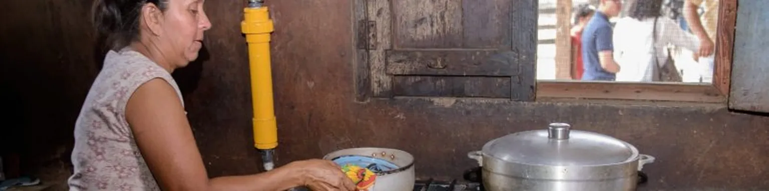 Lady cooking on biogas.