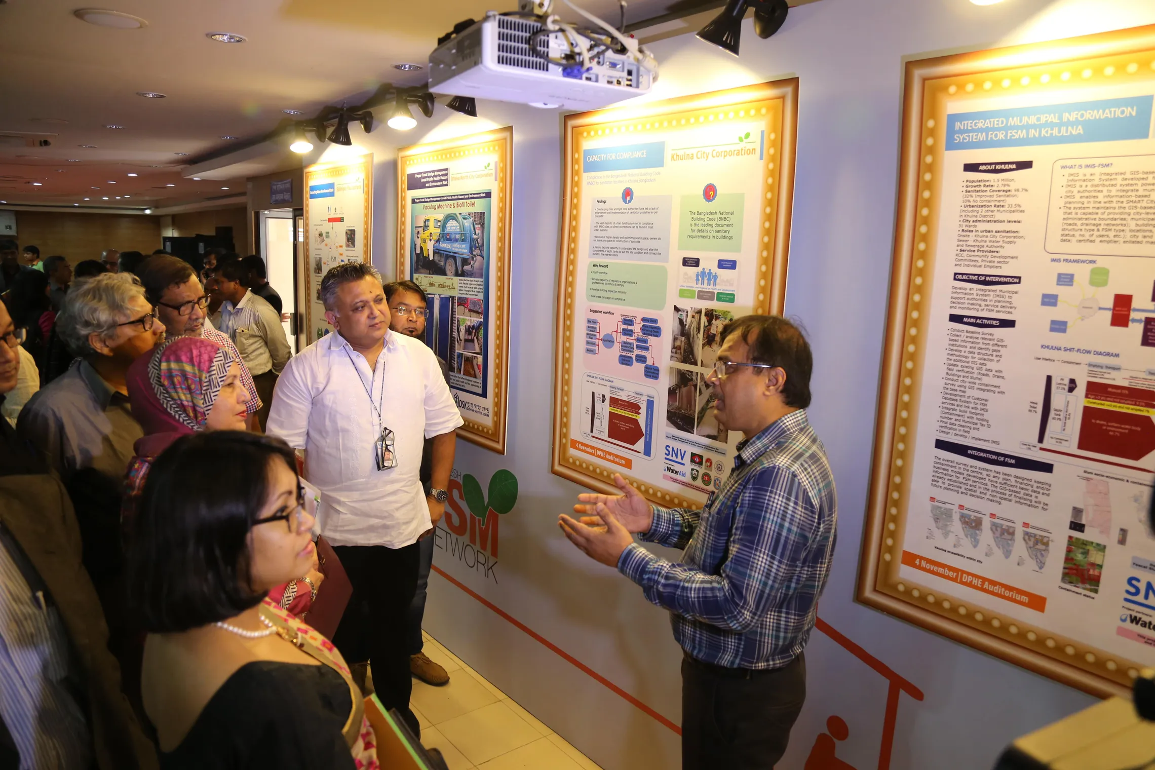 man talking in front of the board "Integrated municipal information system for FSM in Khulna"