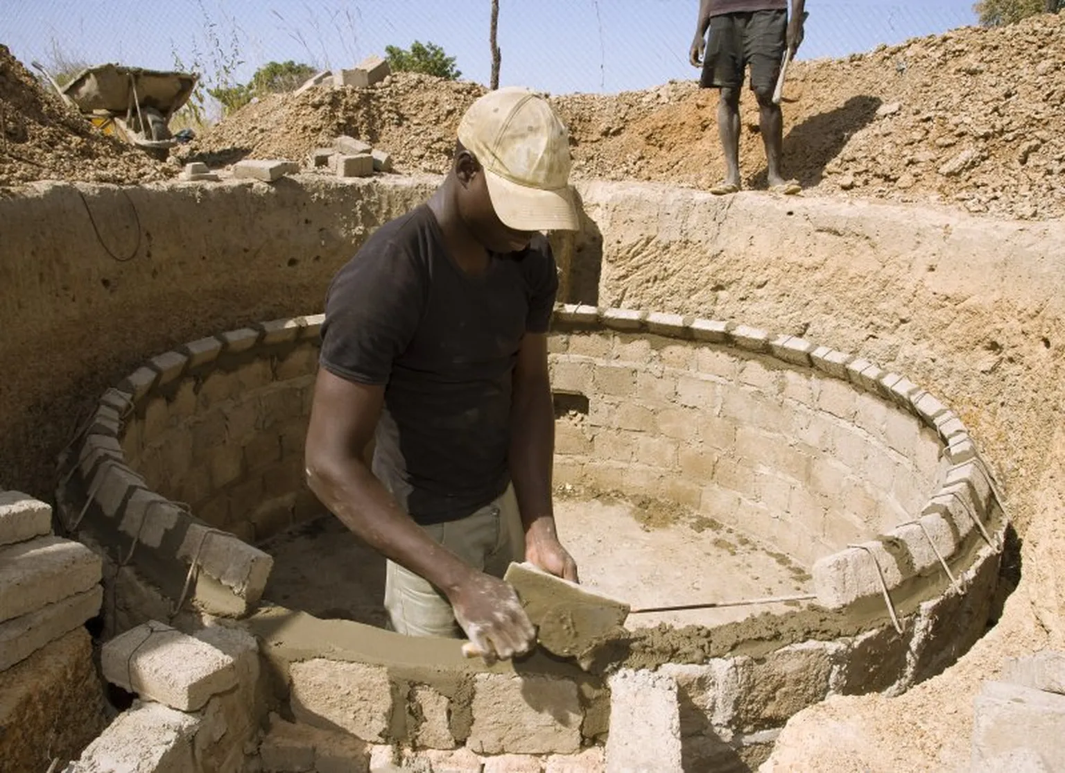 A young mason building a biogas digester in Burkina Faso