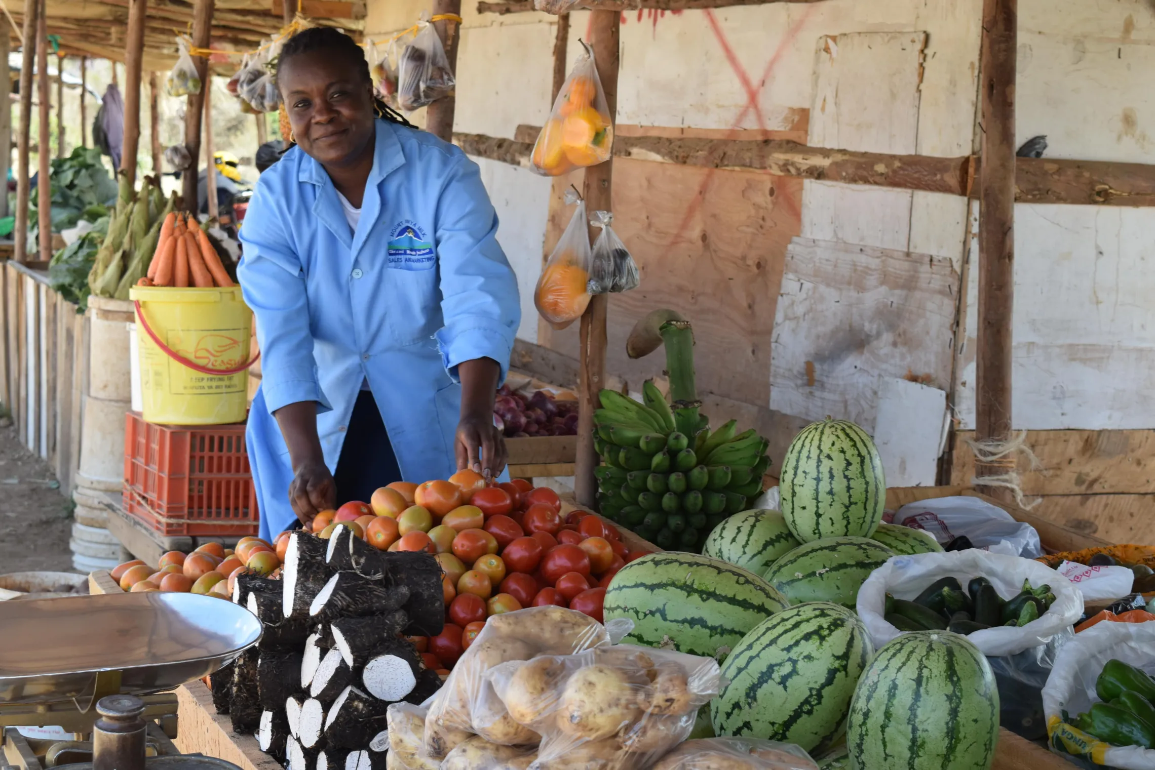 woman standing near fresh fruits and vegetables on a stand
