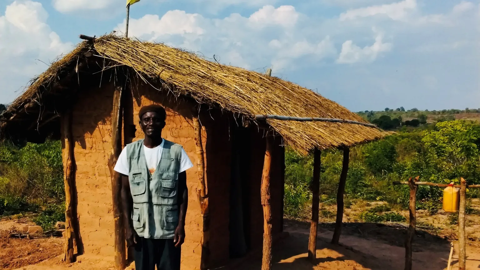 Community leader in Zambezia province stands in front of his new toilet 