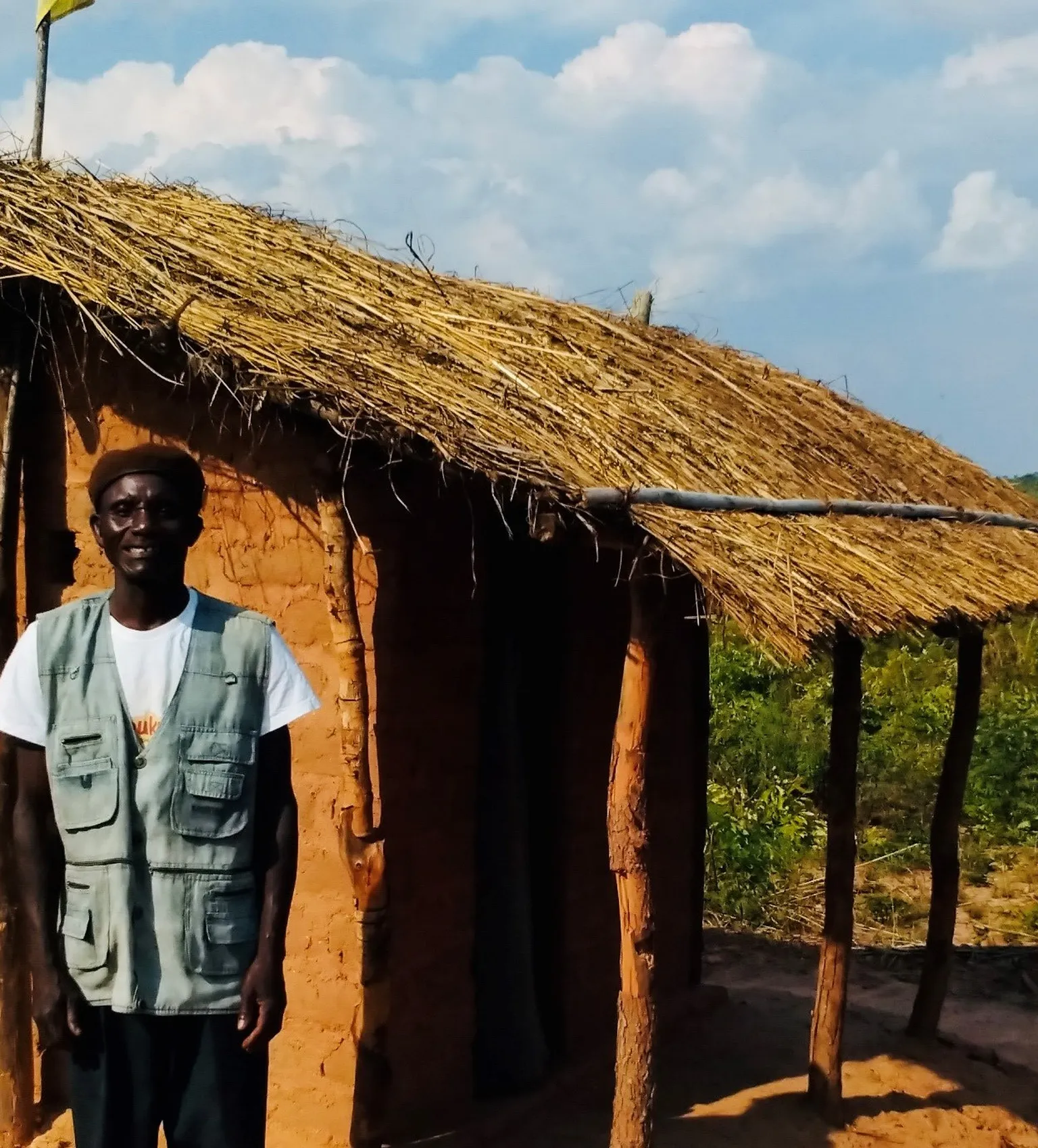 Community leader in Zambezia province stands in front of his new toilet 