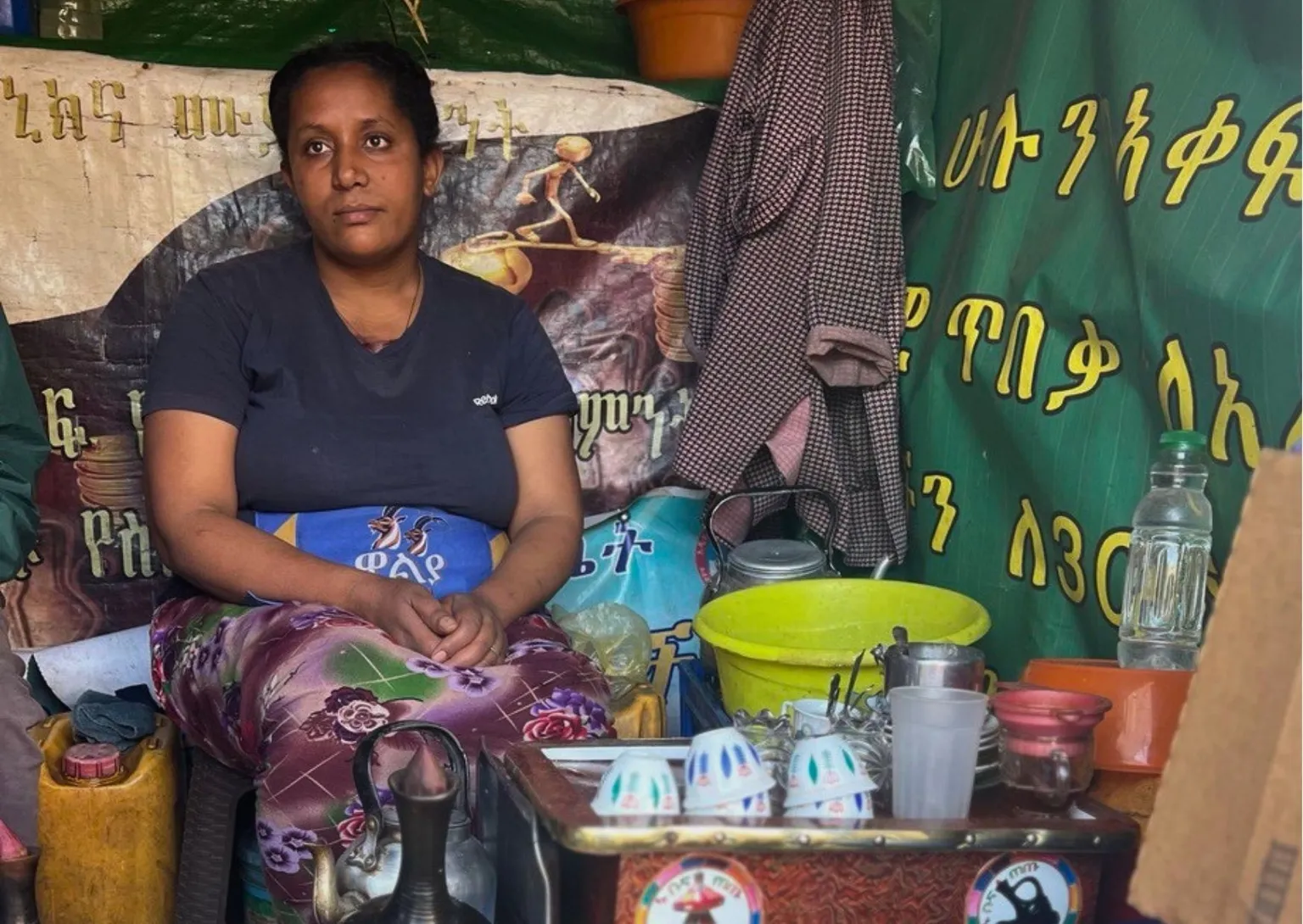 A woman sitting next to her coffee station