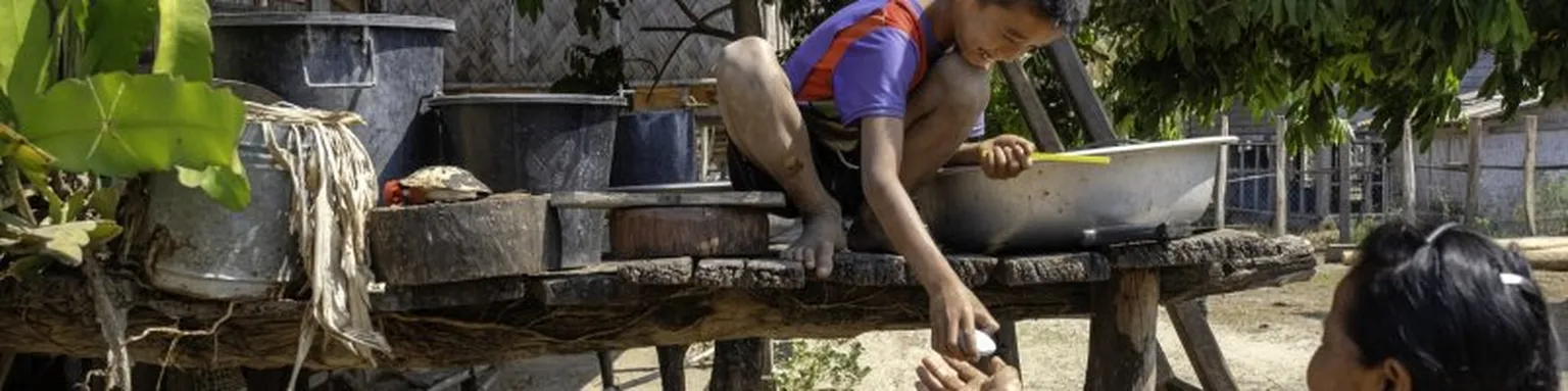 Boy receiving soap from a woman.