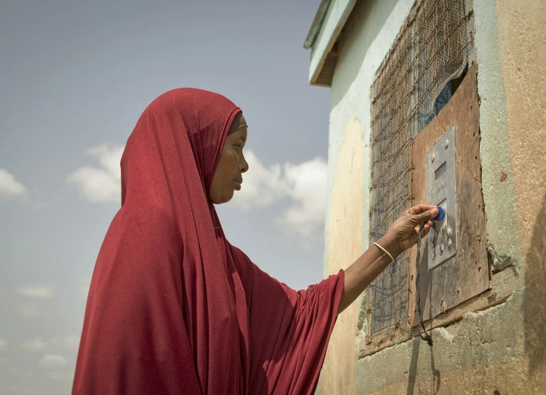 Arron Gesar holds token to collect water from a Water ATM in Hadado Kenya