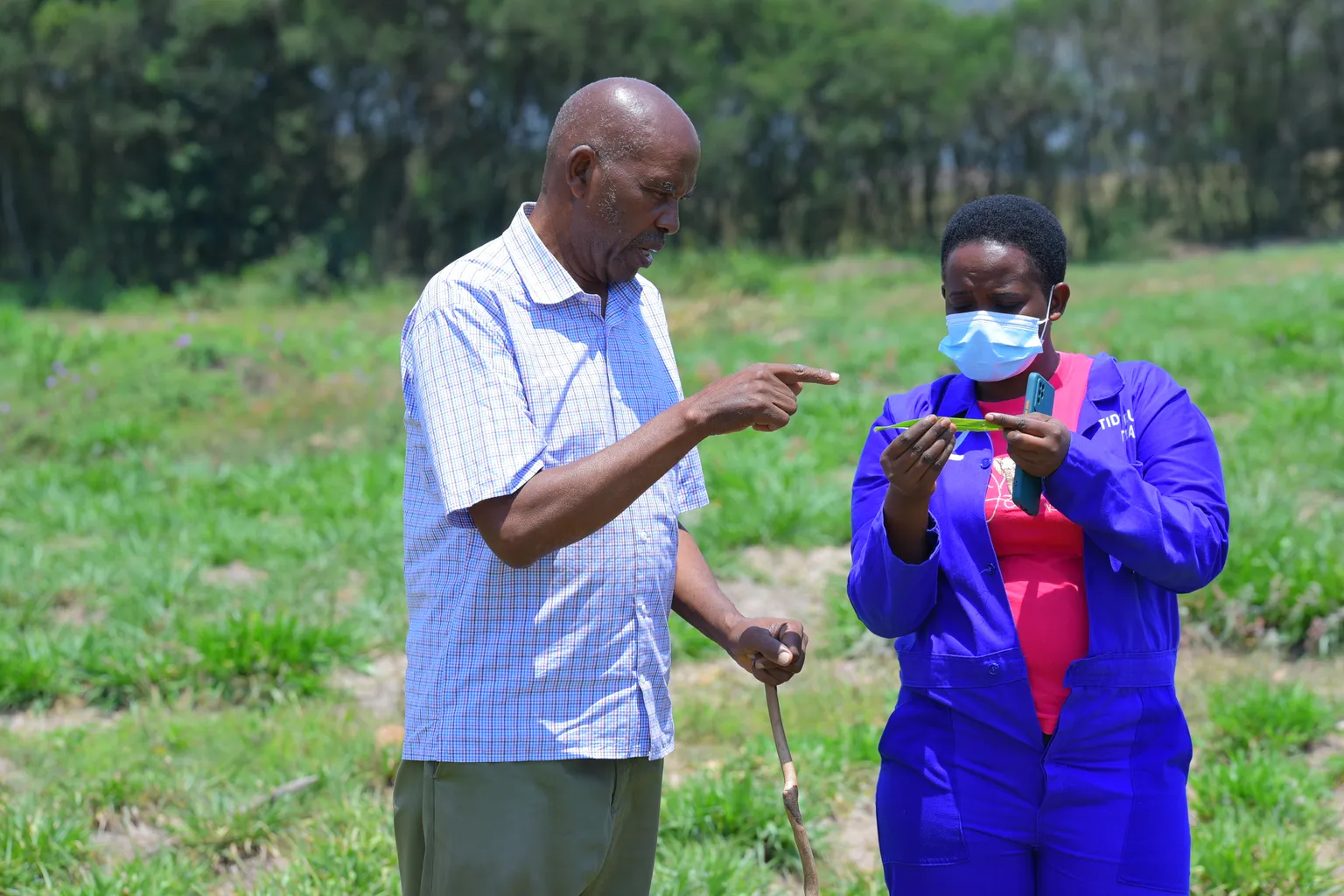 A man and a woman speaking in a field