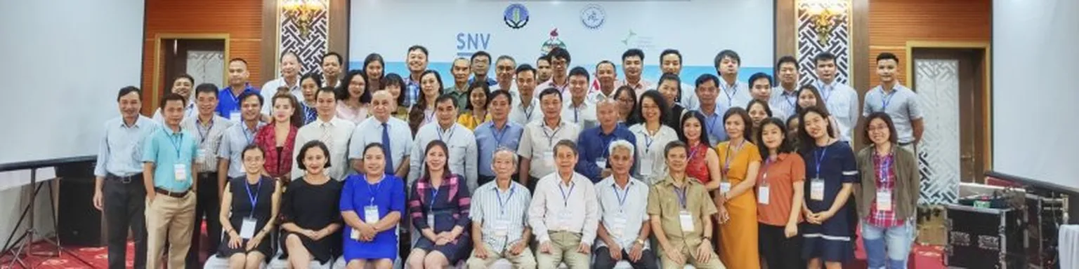 Group of people standing in front of SNV banner