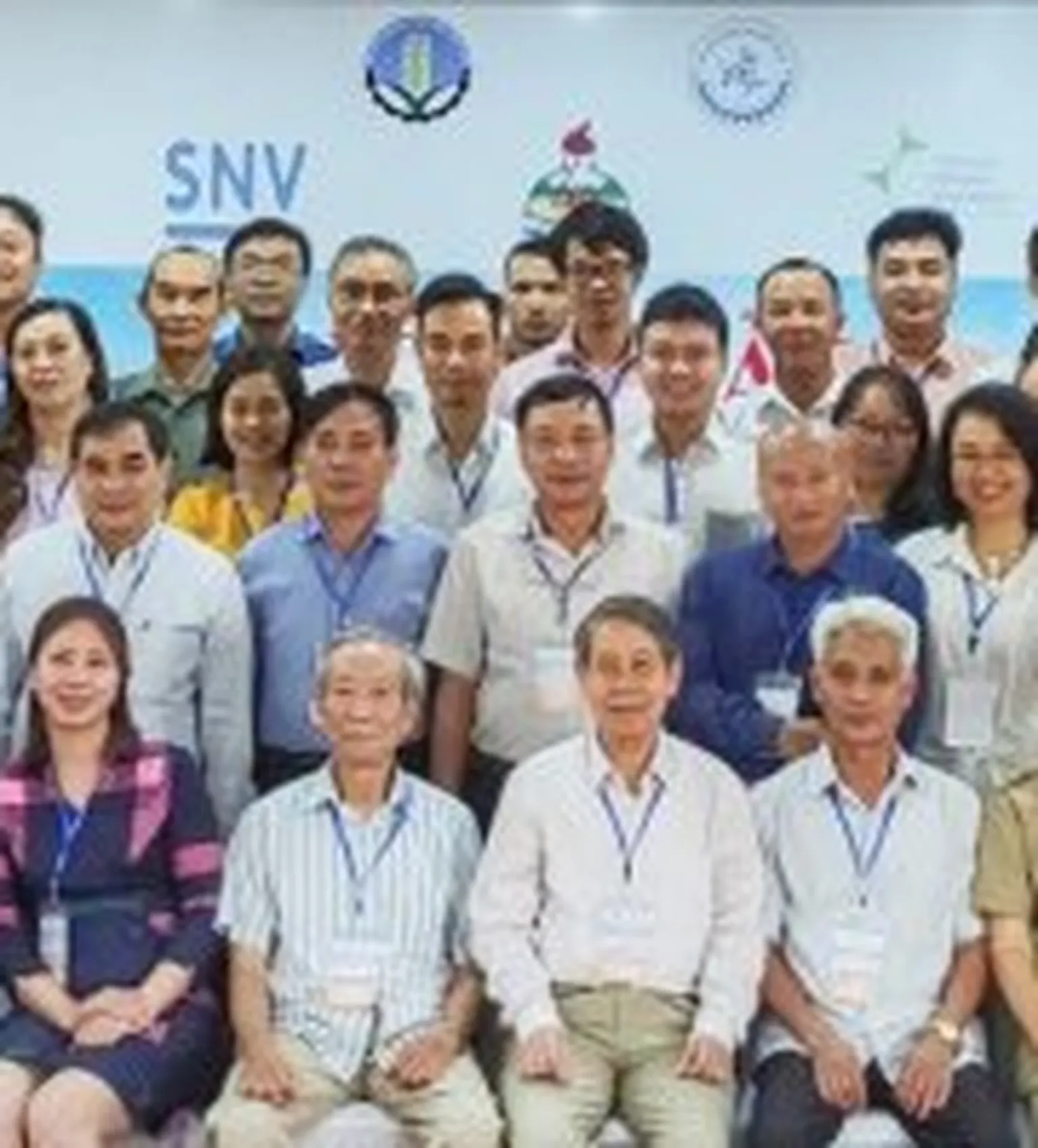 Group of people standing in front of SNV banner