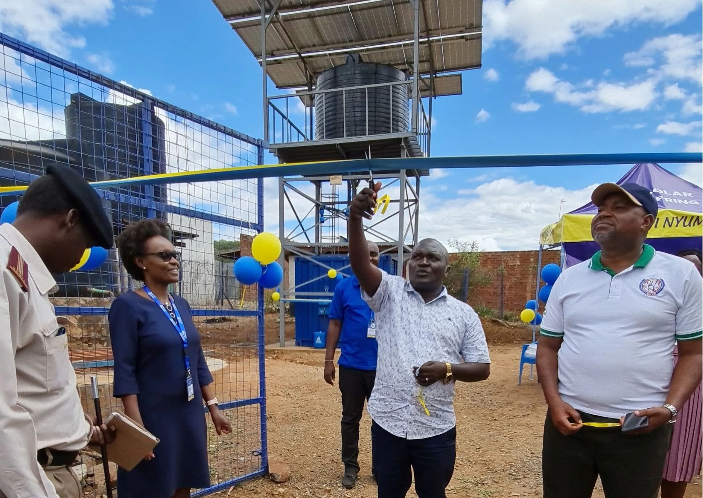 Hon. Emmanuel Kisangau, Minister for Water in Kitui County Government cuts the ribbon to mark the official commissioning of the SSL’s Ndauni Market Station