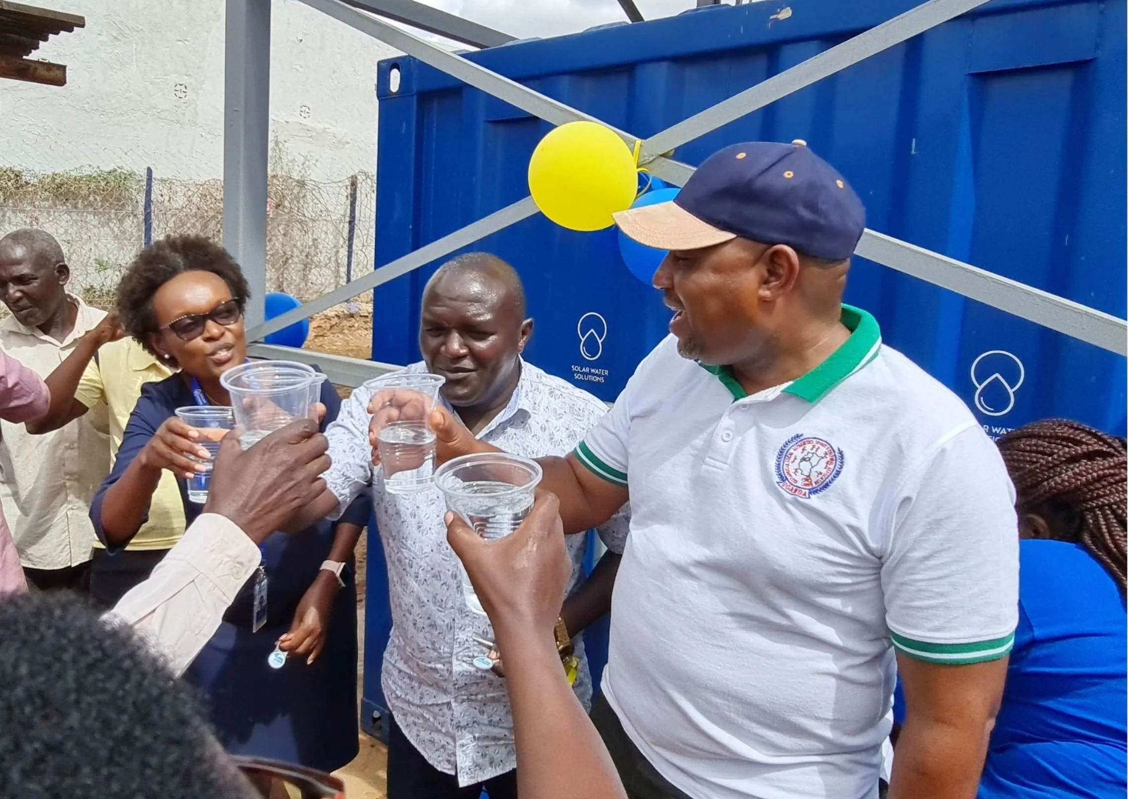 Honourable Emmanuel Kisangau is flanked by Ms. Mary Njue Solar Spring Limited CEO and Honourable Peter Mwikya, MCA Kitui South to a toast with the community members after the launch