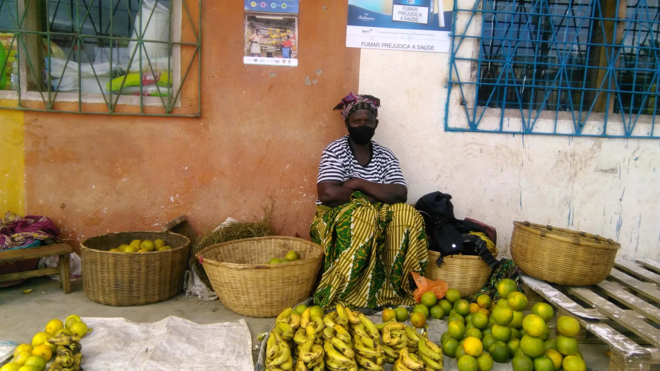 HBCC poster behind market trader to remind market goers of good hygiene practice