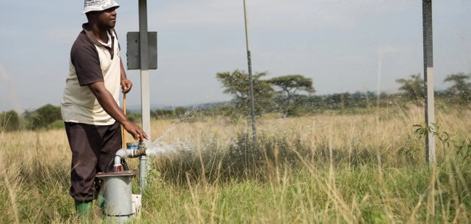 Man with waterpump in field