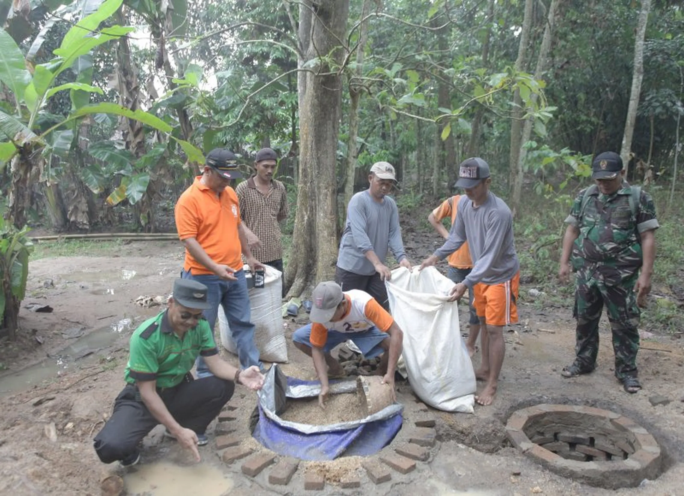 Residents and military personnel build septic tanks together