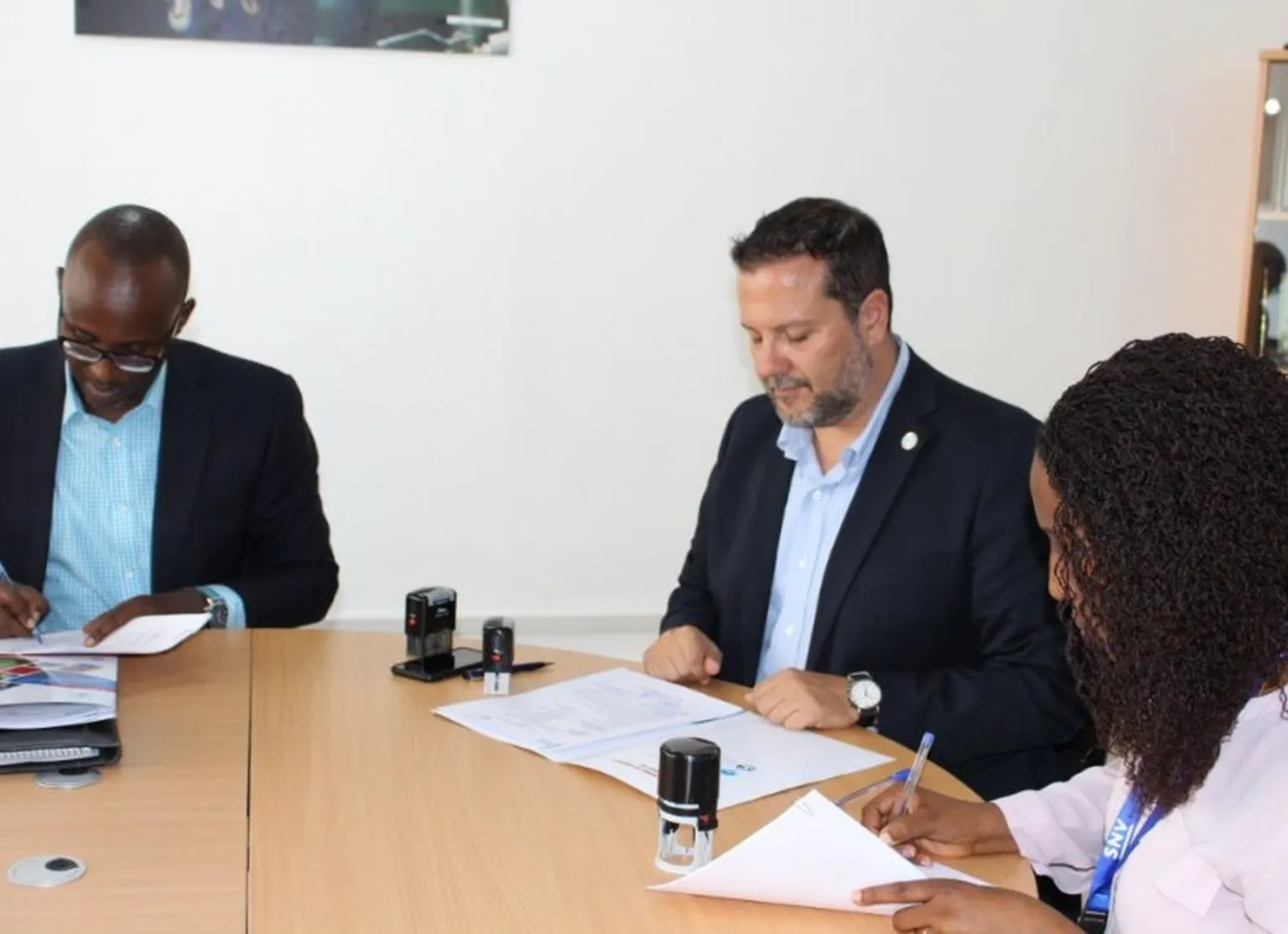 People signing papers at desk