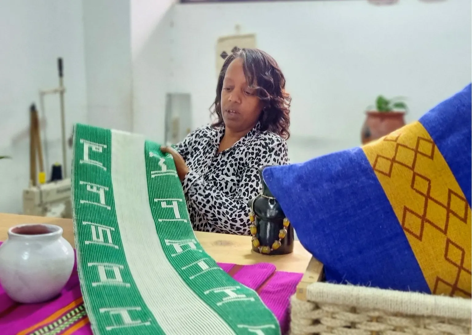 A woman showcases her hand crafts in a bazar.