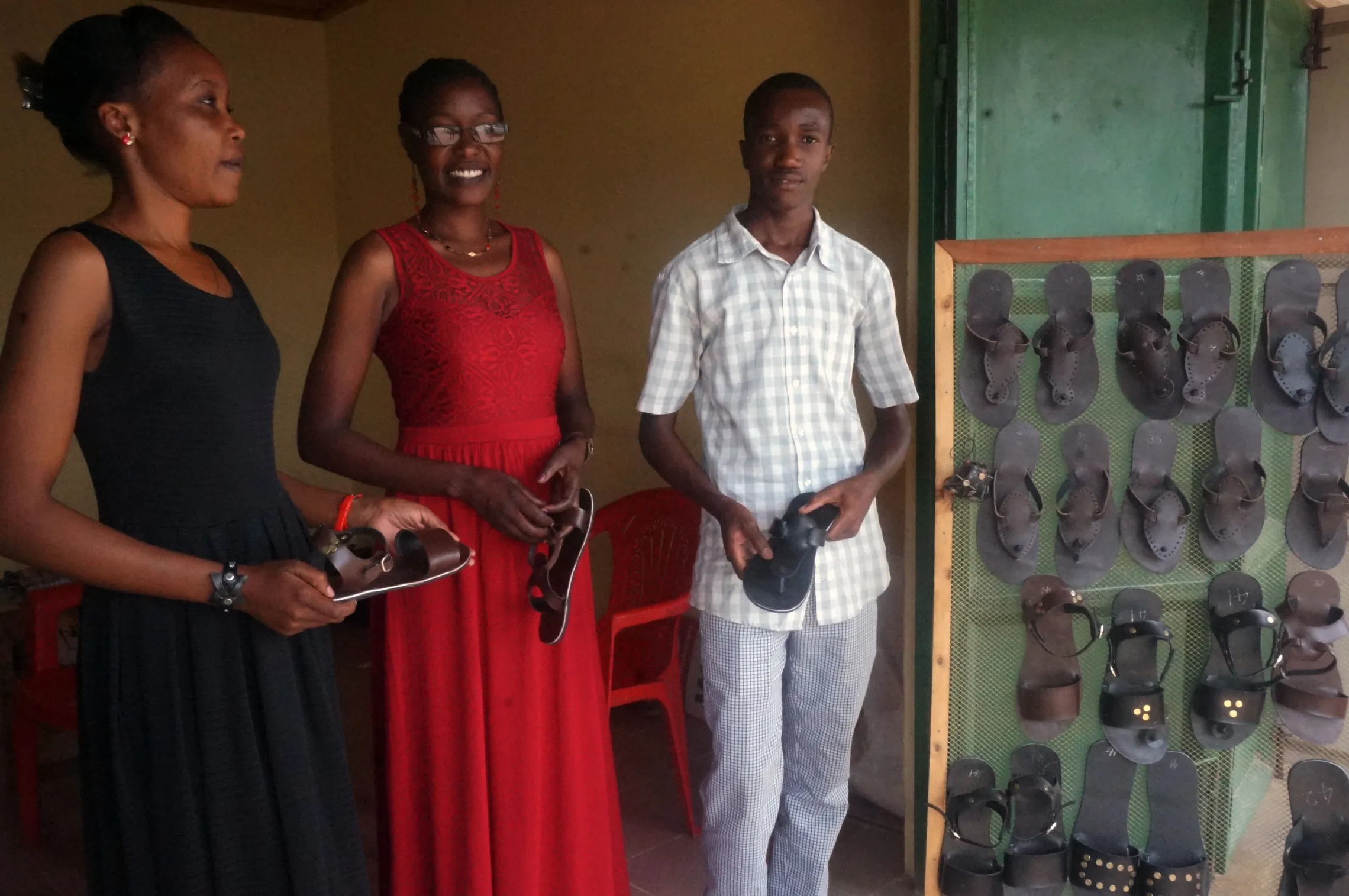 three people standing in front of the stand with shoes