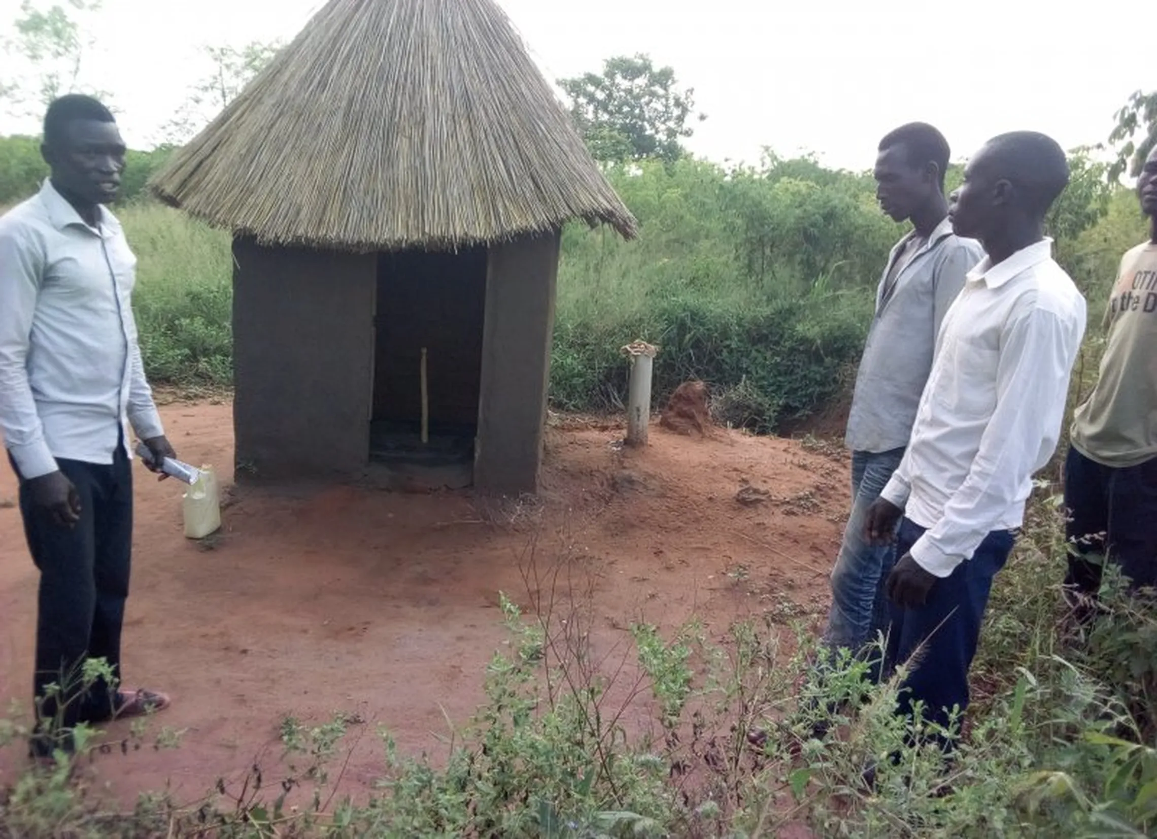 Some of the group's members standing next to a newly constructed latrine