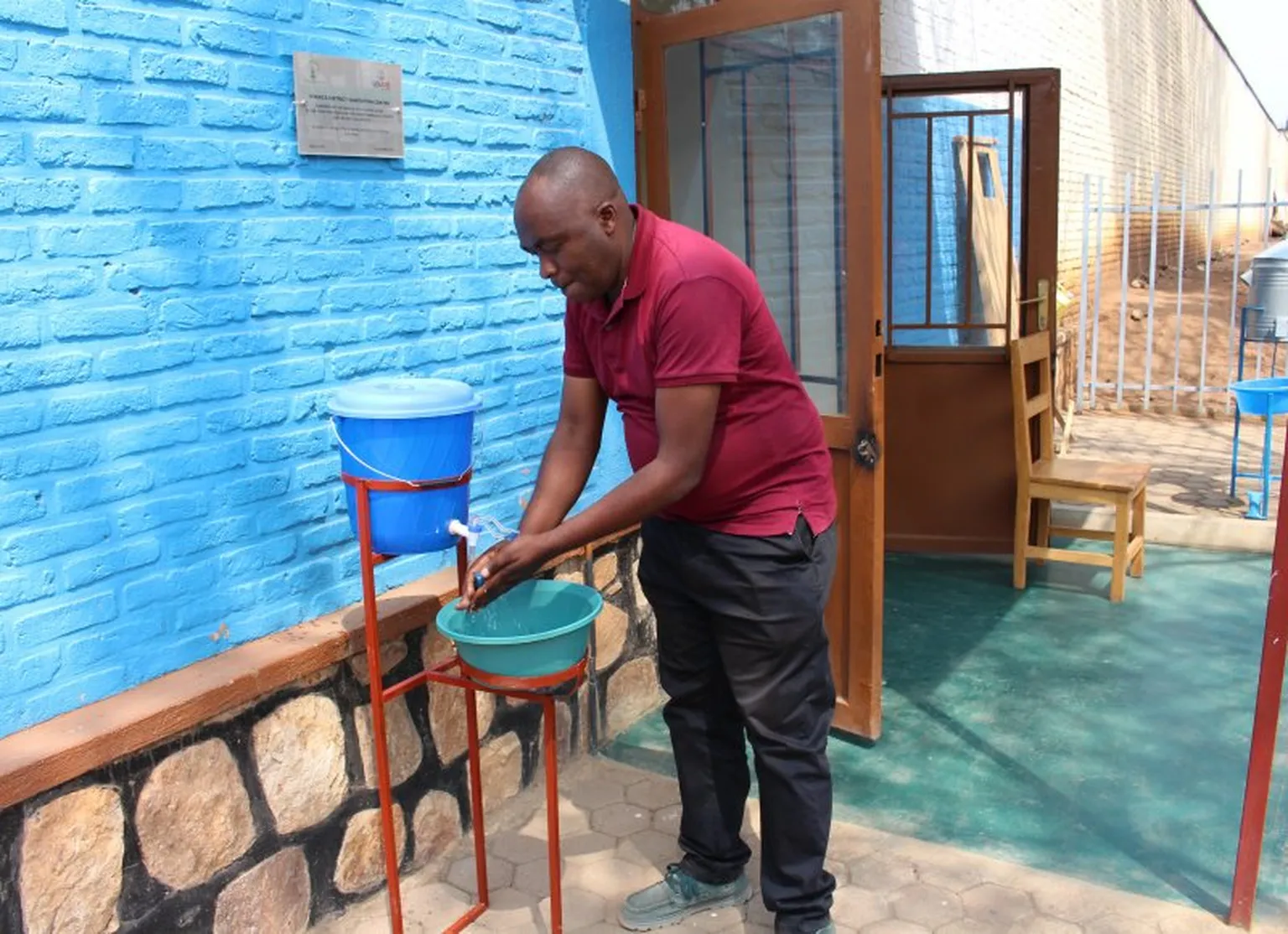 John Munyambonwa demonstrating how his innovative hand washing station works. 