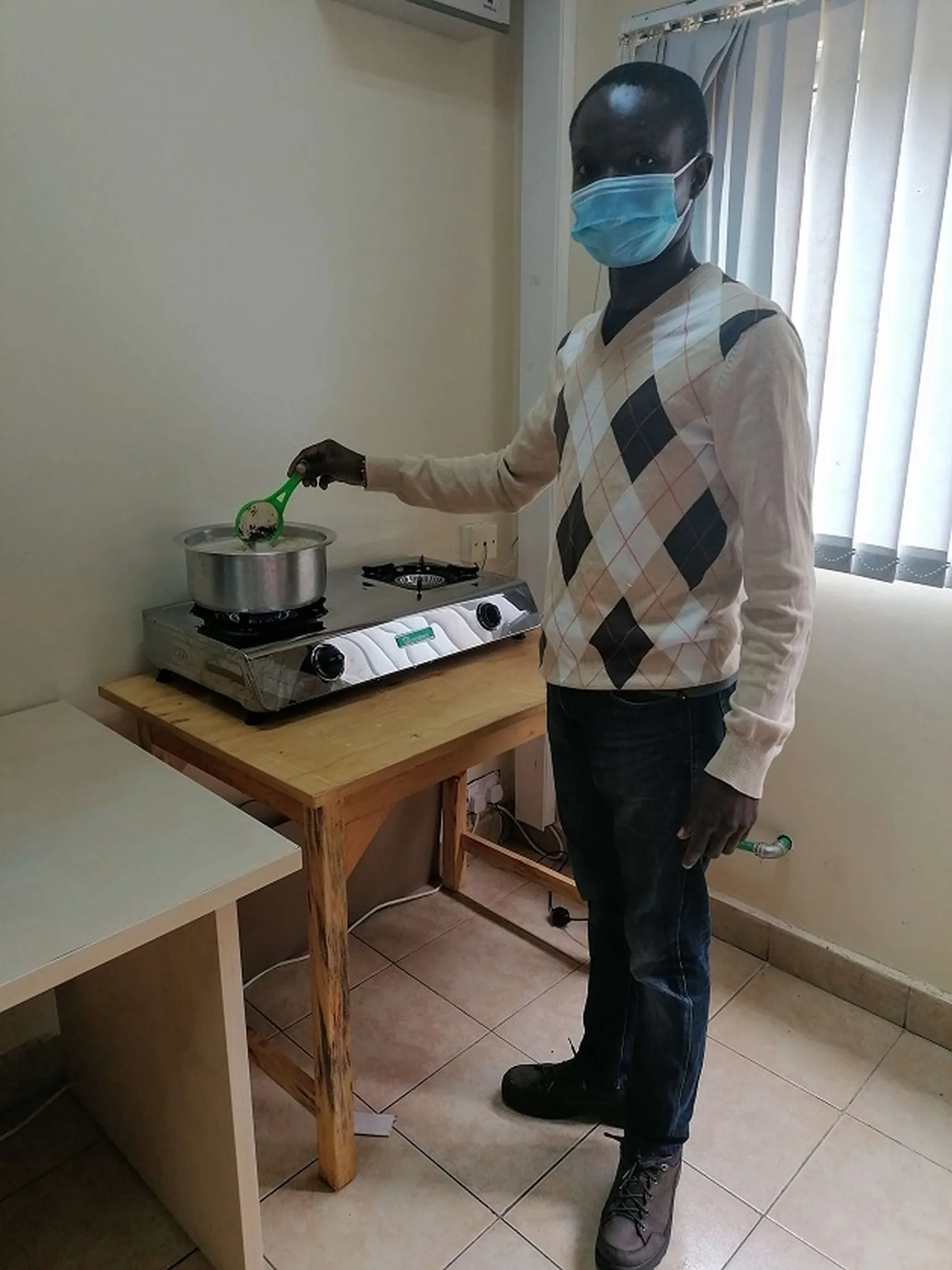 Stanley, office management assistant in Kenya making tea using biogas 