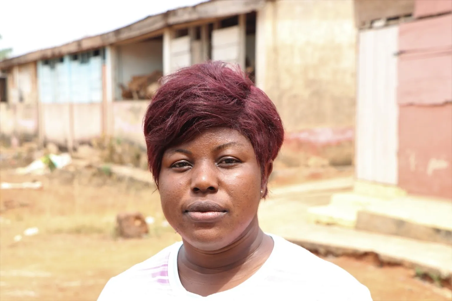 Charlotte Ofobiri standing in front of her workshop located in her community