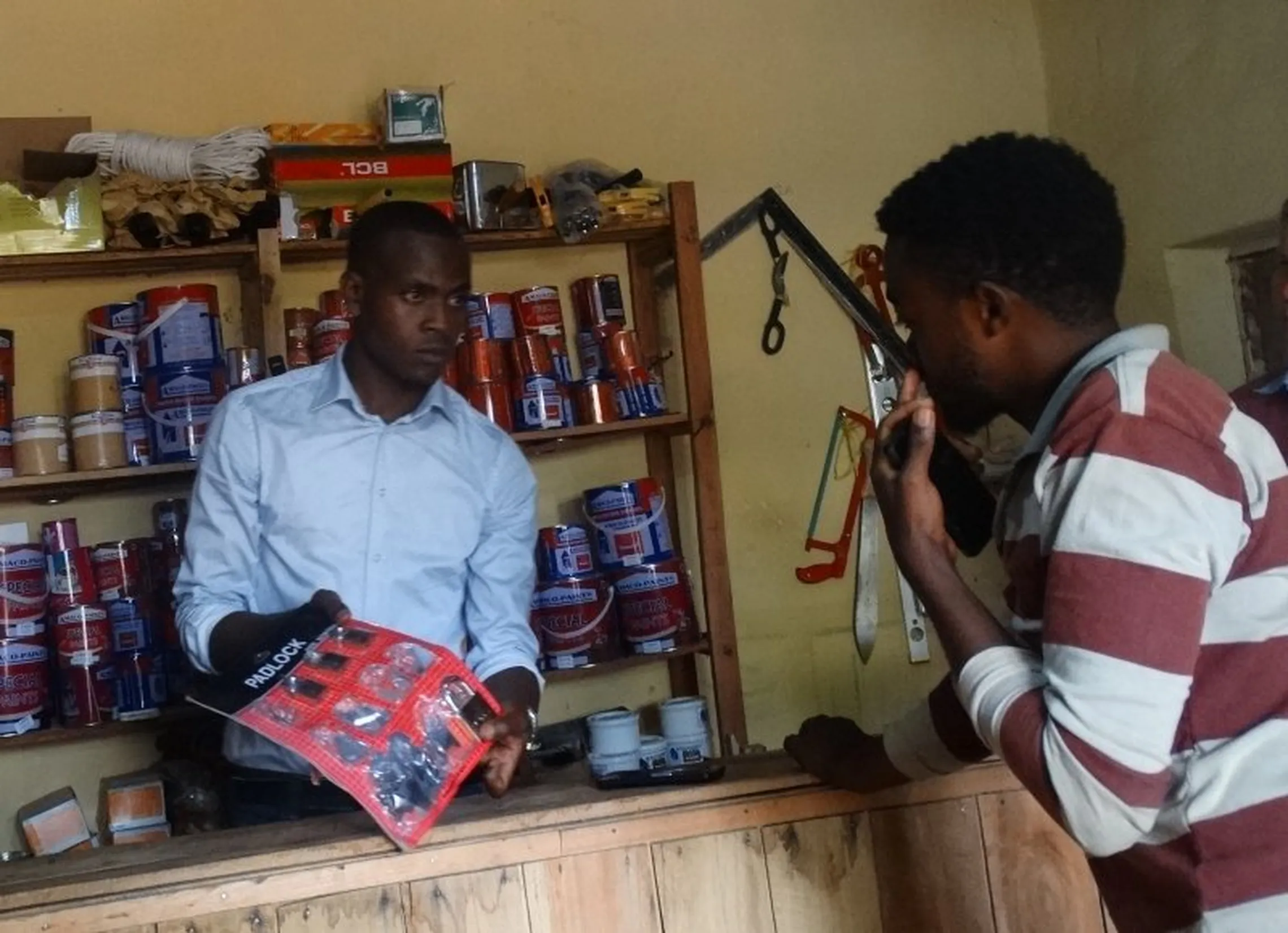 Vedaste with a customer in his store