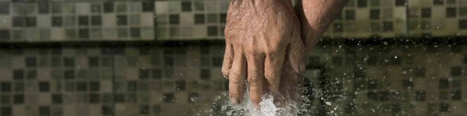 Hands being sprayed by water.