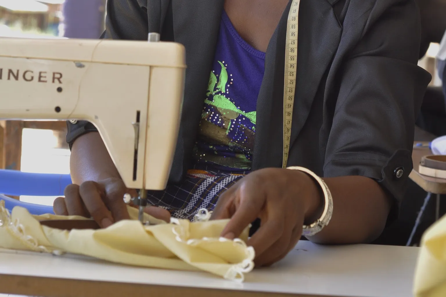 Scovia, young embroidery entrepreneur and tailor. Click to read her story.