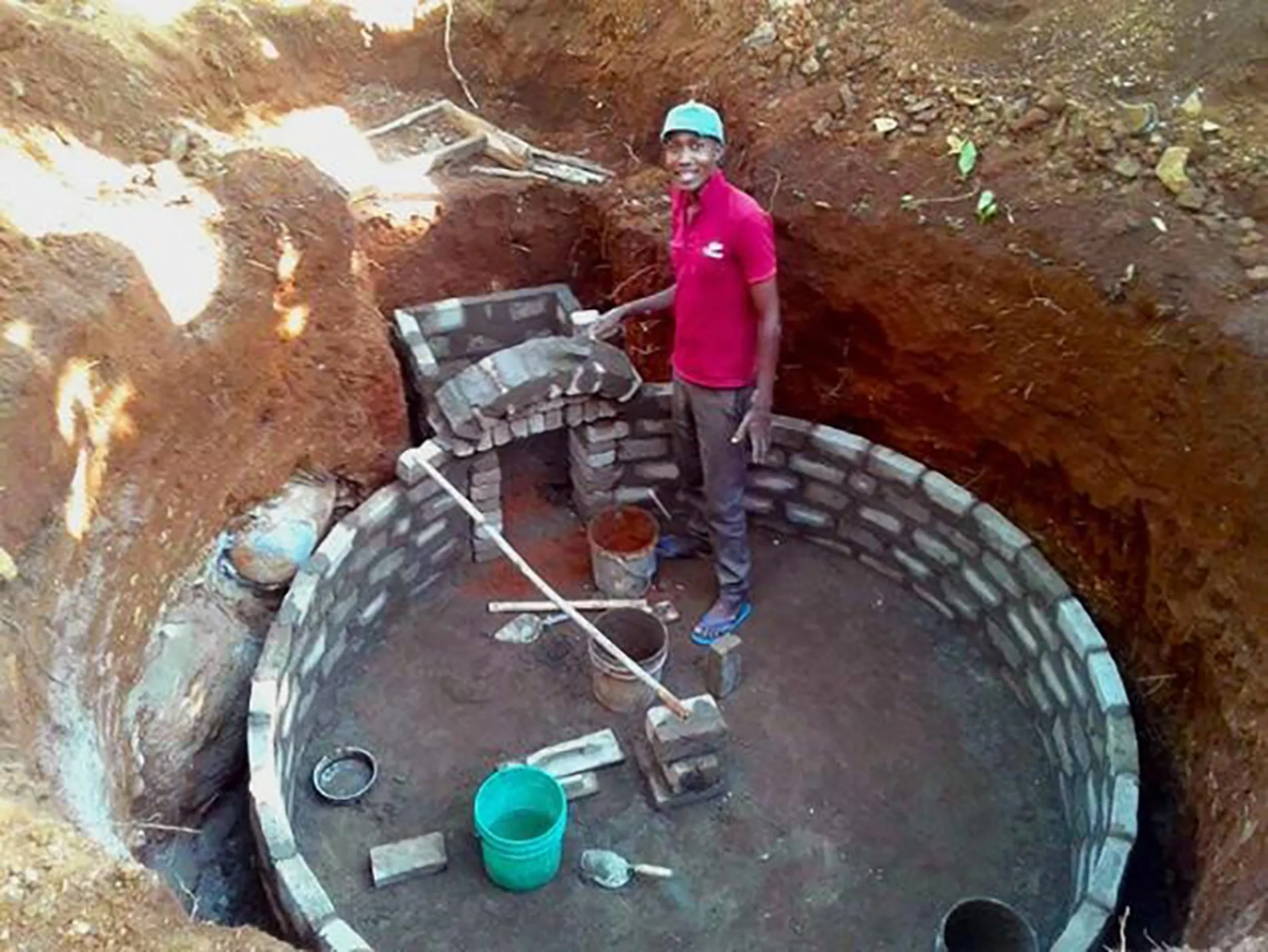 Gabriel Mafinanga building a bio-digester 