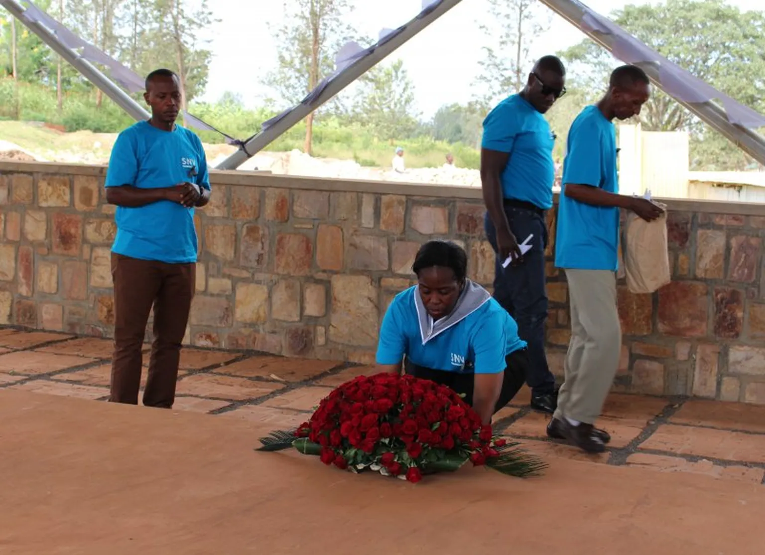 Country Director Phomolo Maphosa places a wreath on one of the mass graves